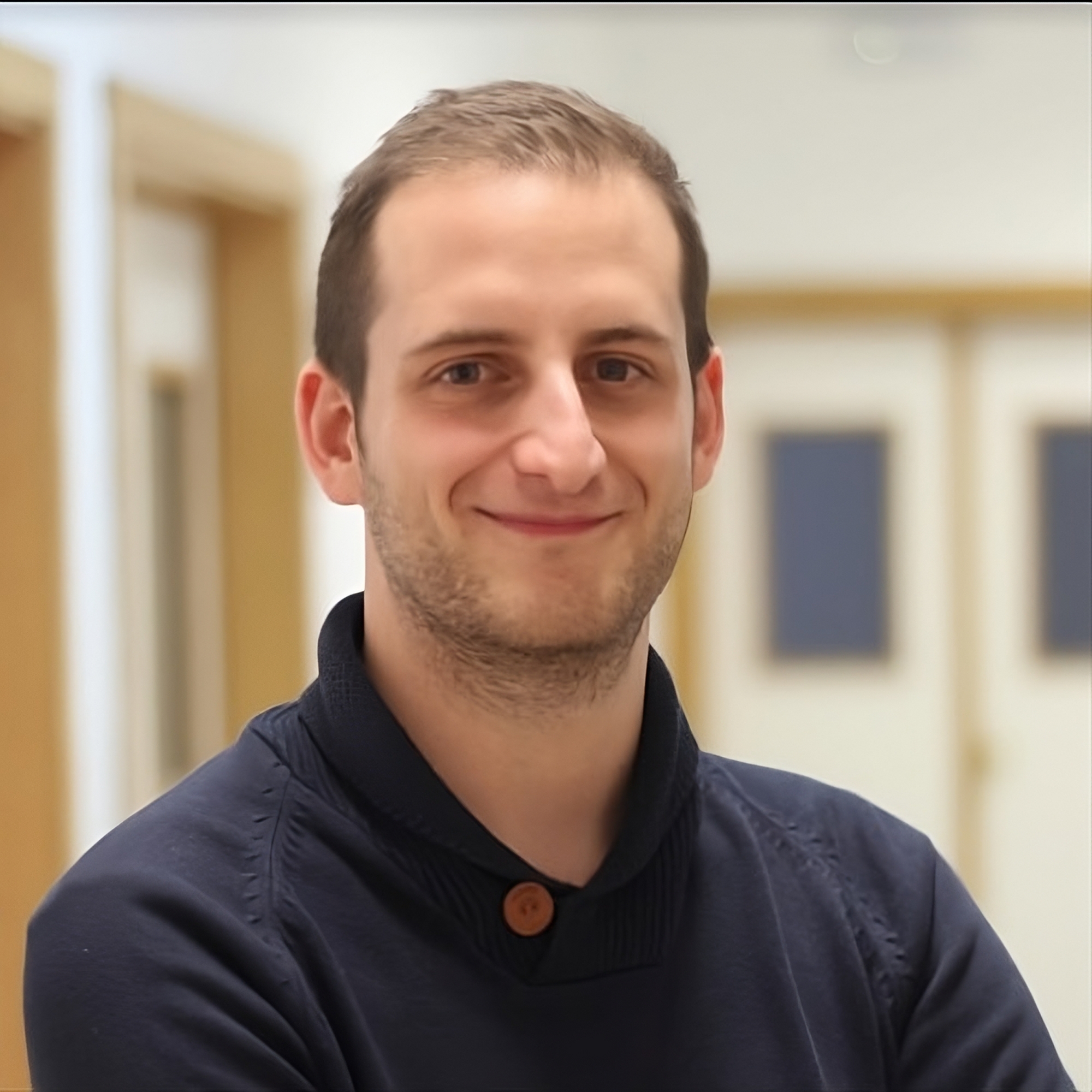 Jesús Vergara Castellano, especialista en marketing digital, sonriendo en un entorno de oficina con puertas en el fondo.