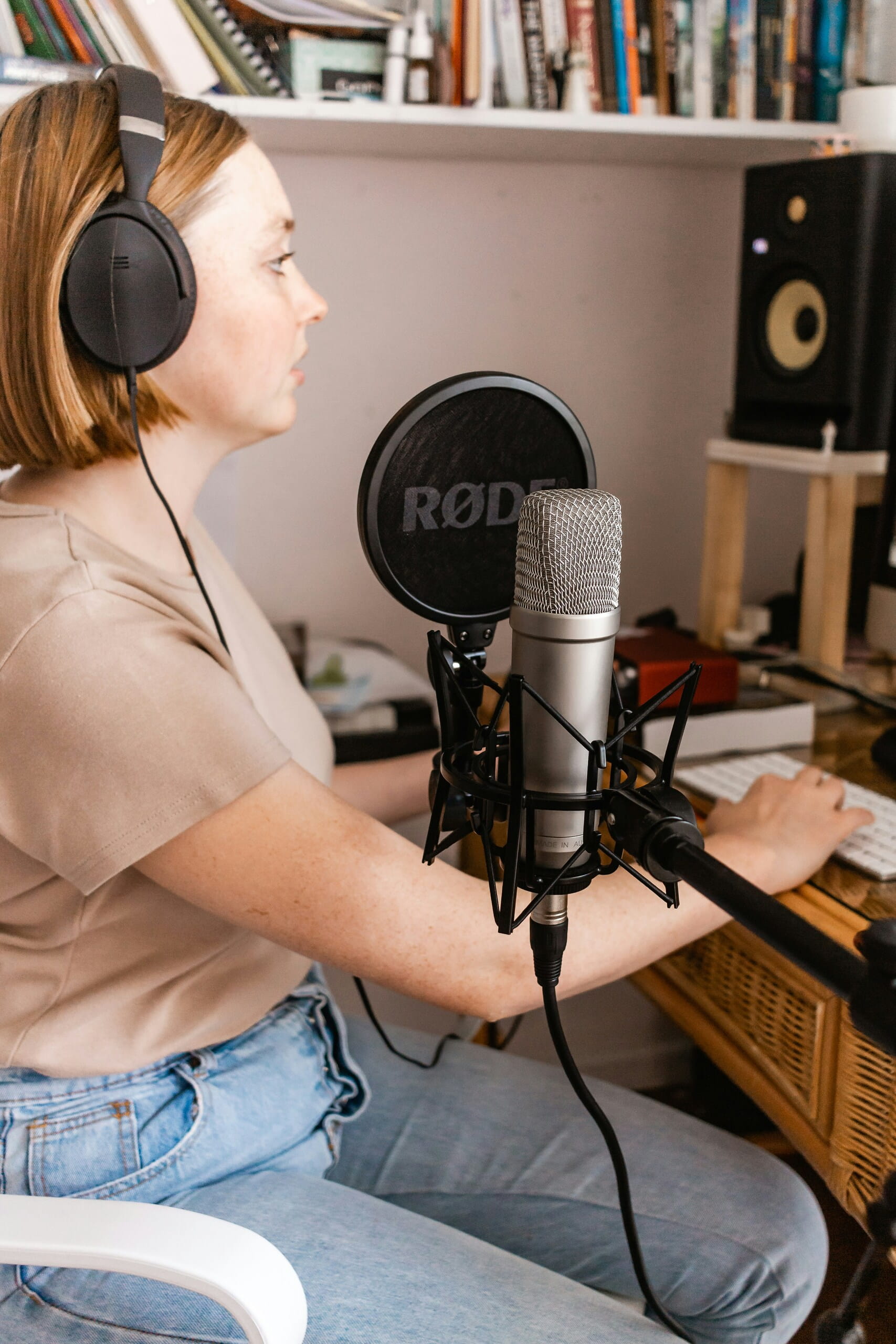 Creadora con micrófono y audífonos en su estudio, ideal para Estrategias para promover contenido viral y crear podcasts.
