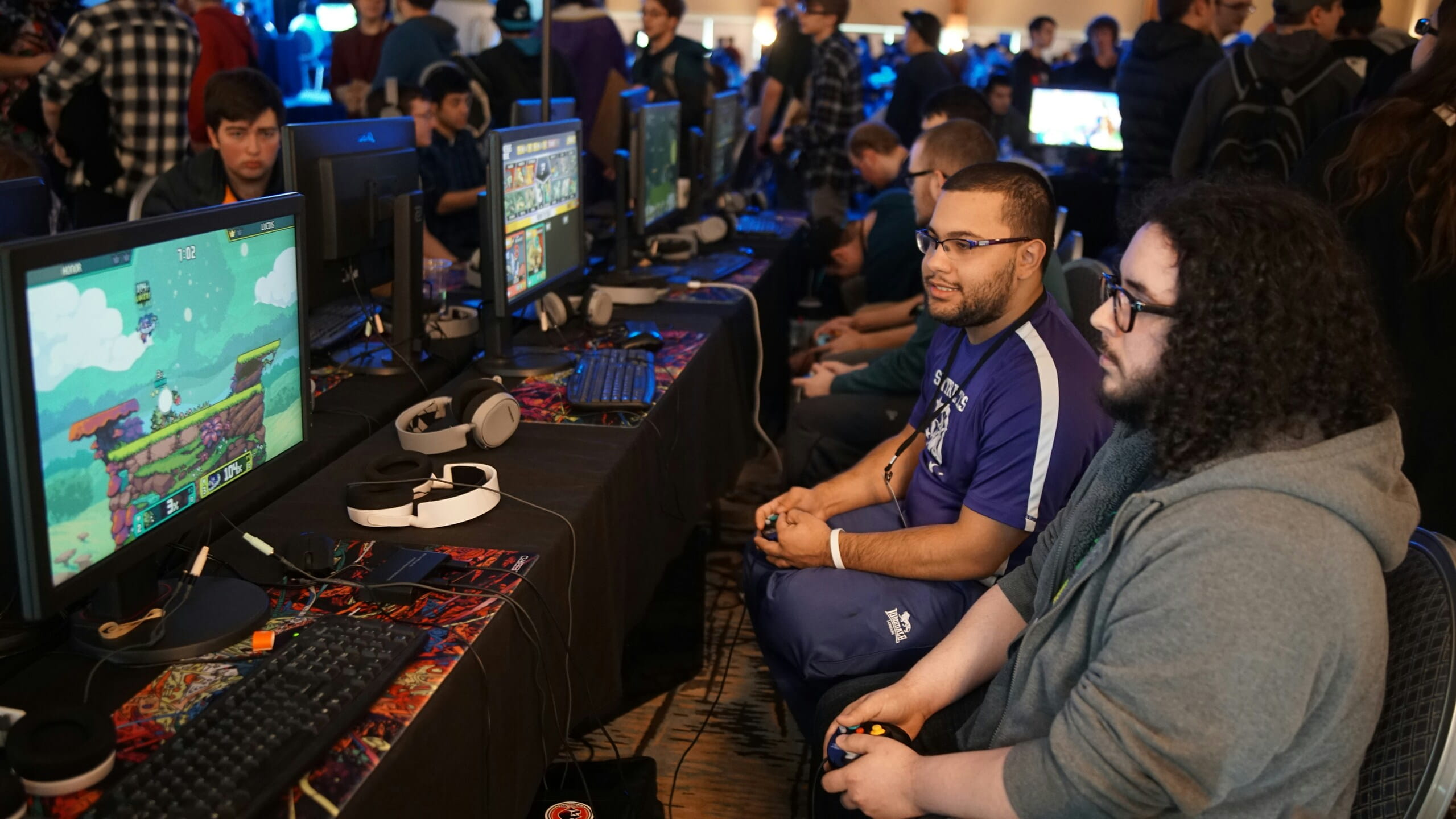 Jugadores en torneo de videojuegos con varios monitores, ideal para Estrategias para promover contenido viral en comunidades online.