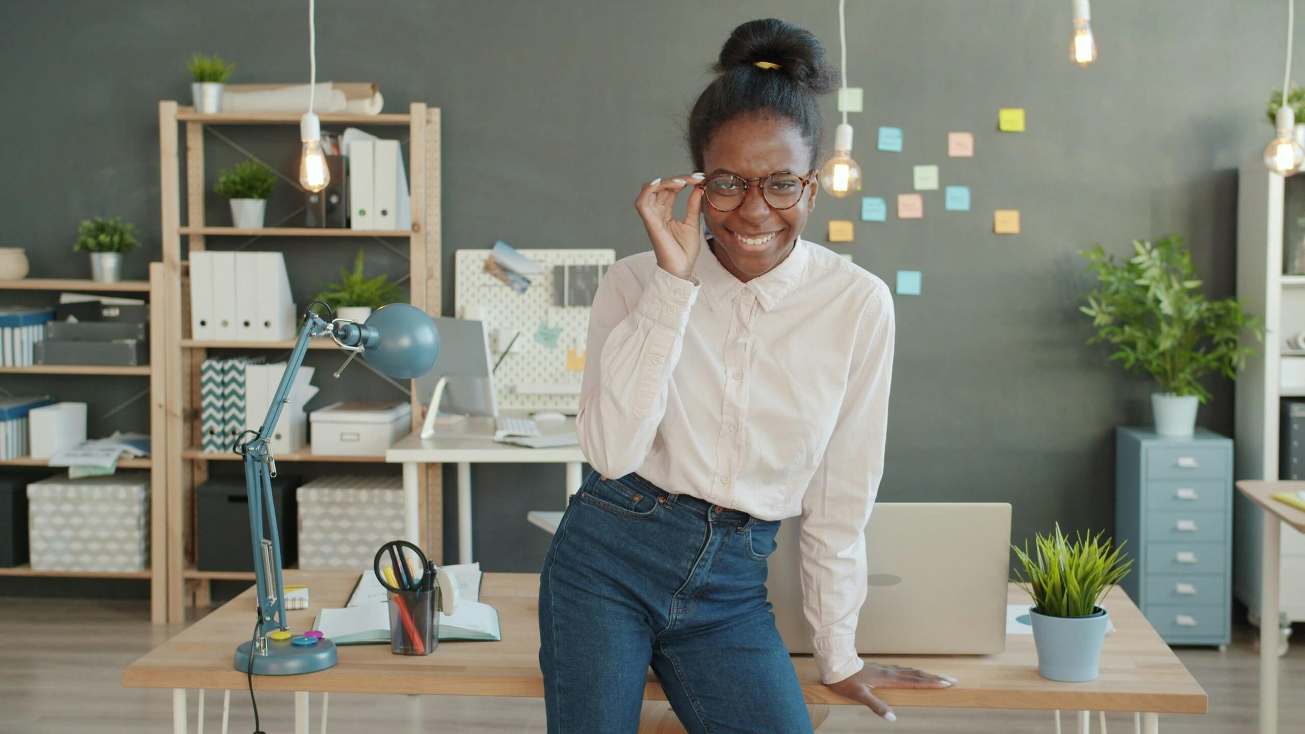 Mujer sonriente en oficina creativa, ideal para Estrategias para promover contenido viral y trabajo de marketing.