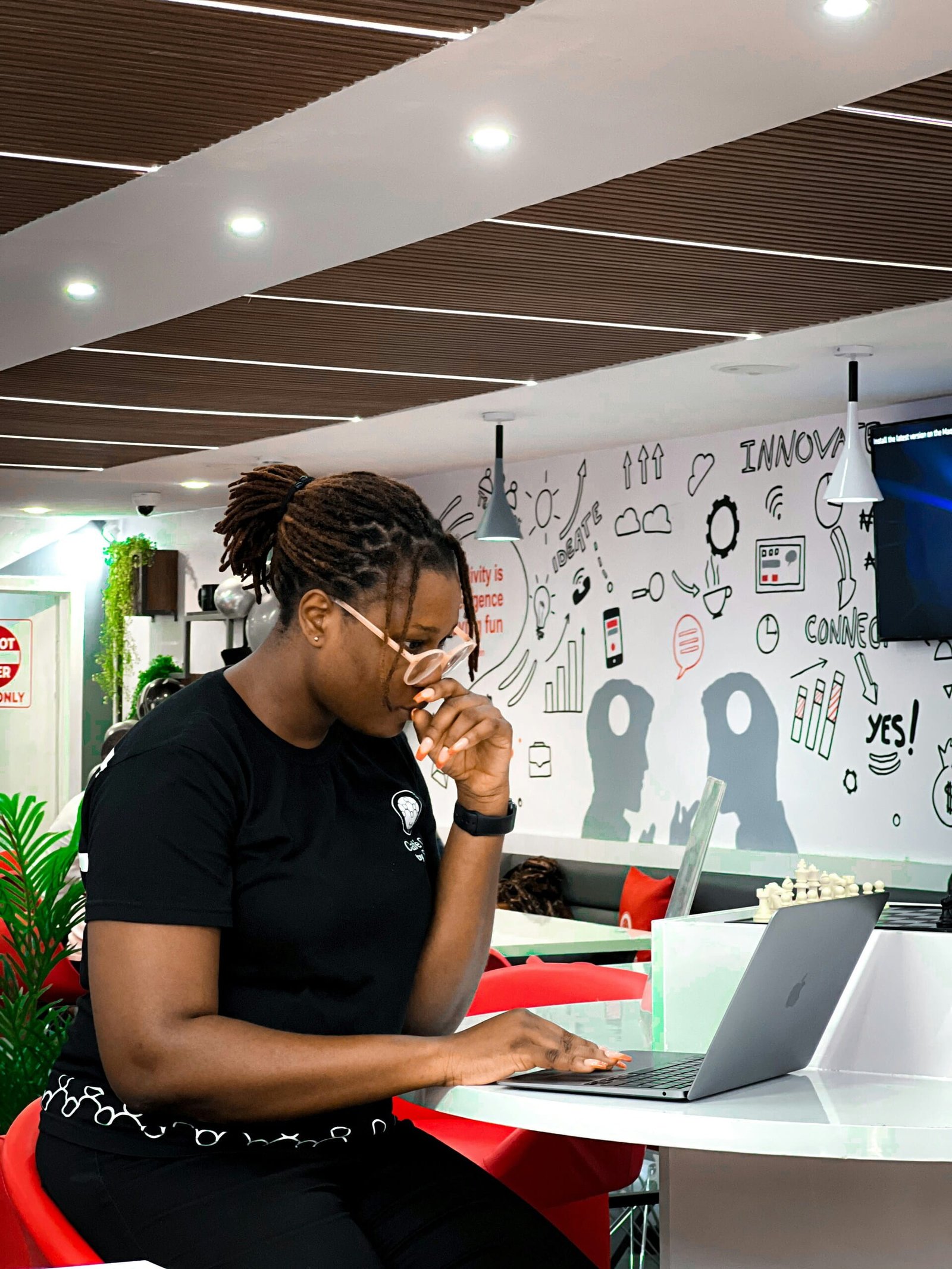 Profesional concentrada trabaja en su portátil y prepara el mensaje y la propuesta de valor en un espacio de coworking.