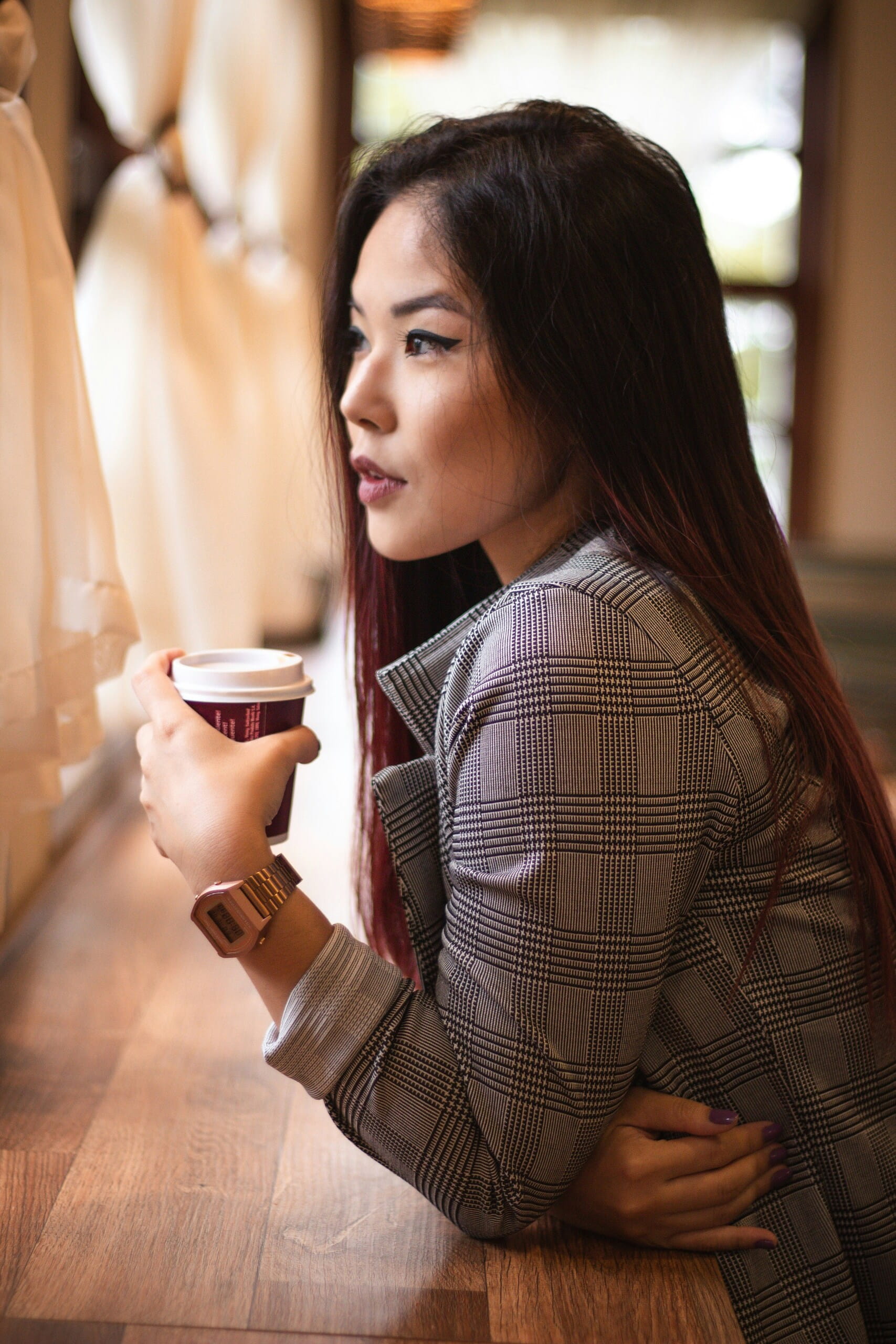 Mujer pensativa con café en una cafetería, útil para Reseñas y reputación local y para reforzar la confianza del negocio.