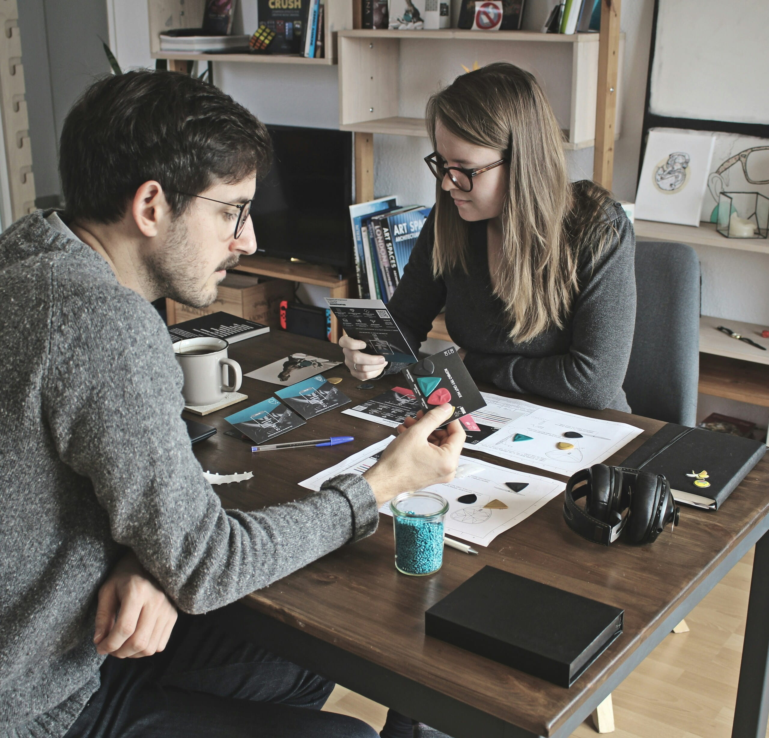 Dos personas analizan materiales de diseño en una mesa, comunicando Storytelling emocional durante una sesión colaborativa.